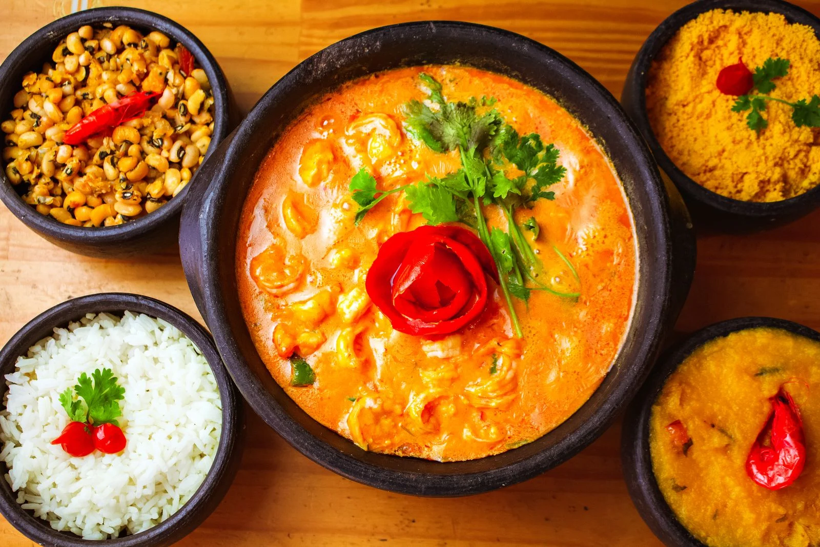 Curry with rice and side dishes garnished with fresh herbs