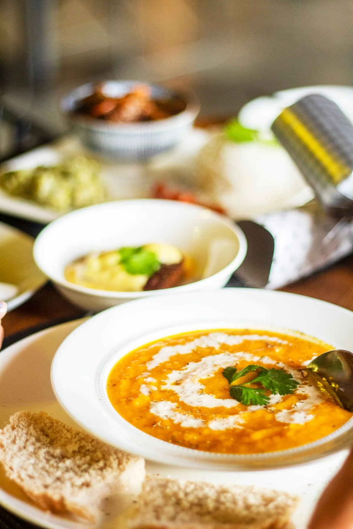 Curry with colourful side dishes on a wooden table