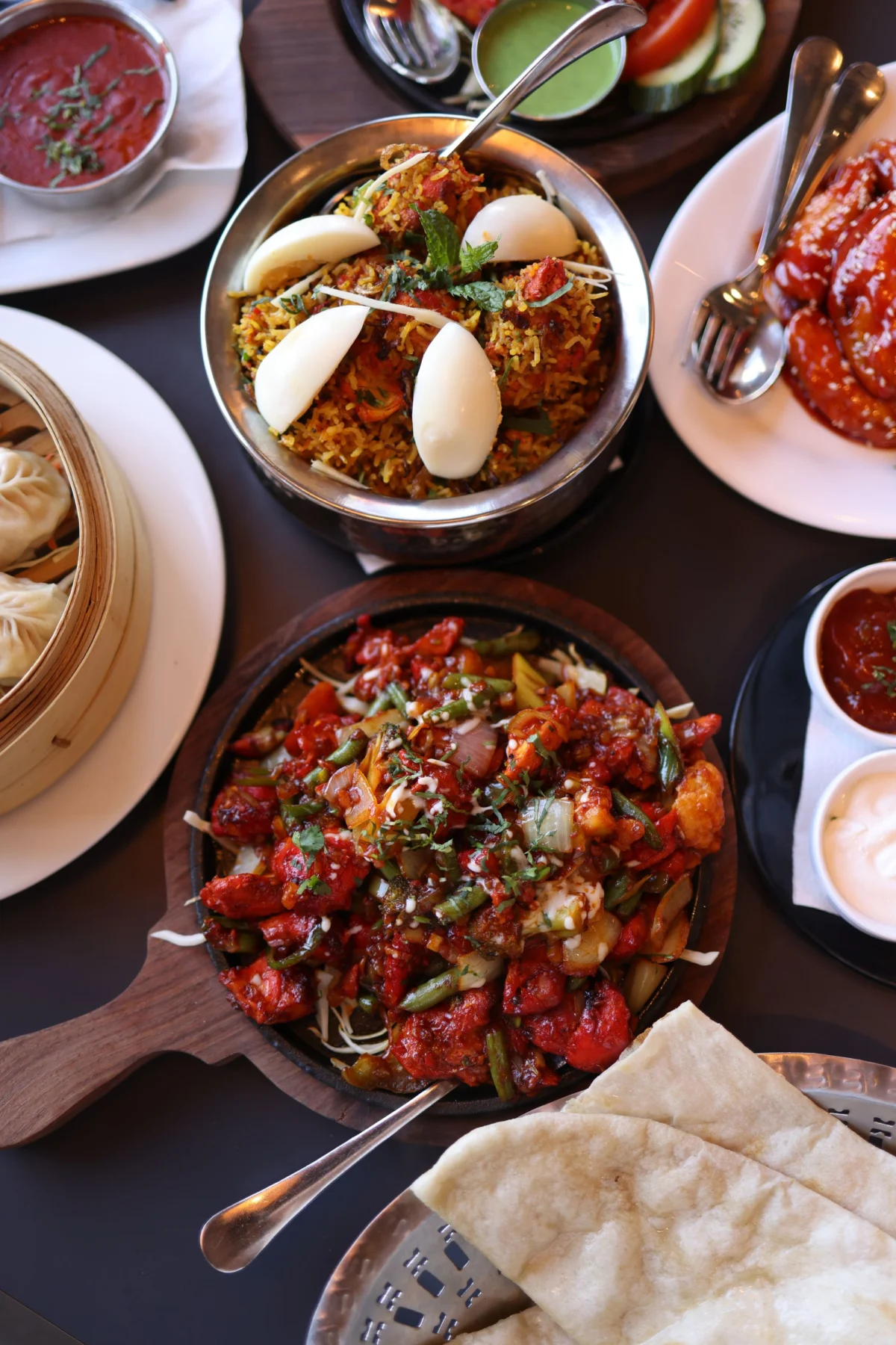 A table filled with biryani, curries and sharing plates