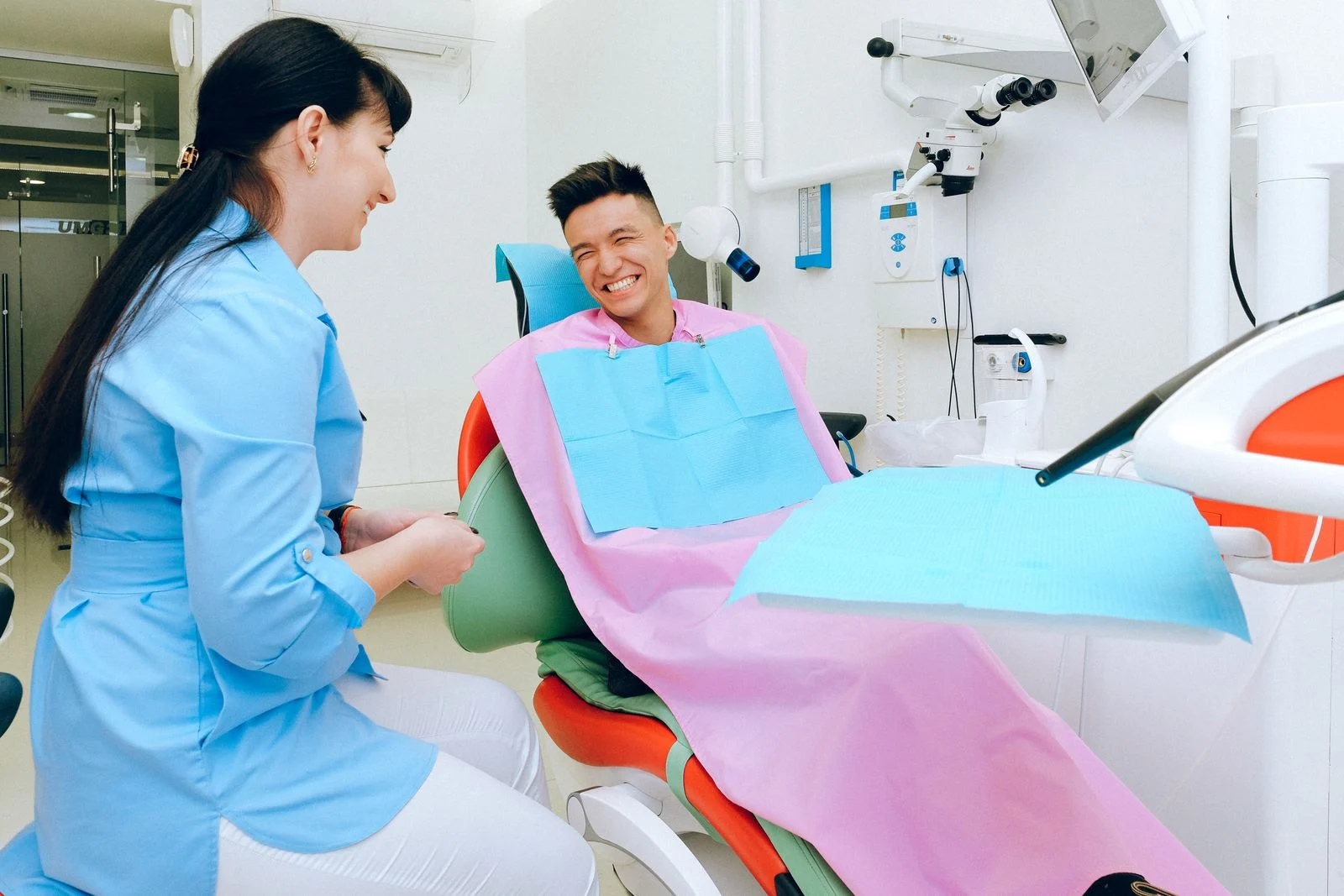 Smiling man in a dental chair talking with his dentist before treatment