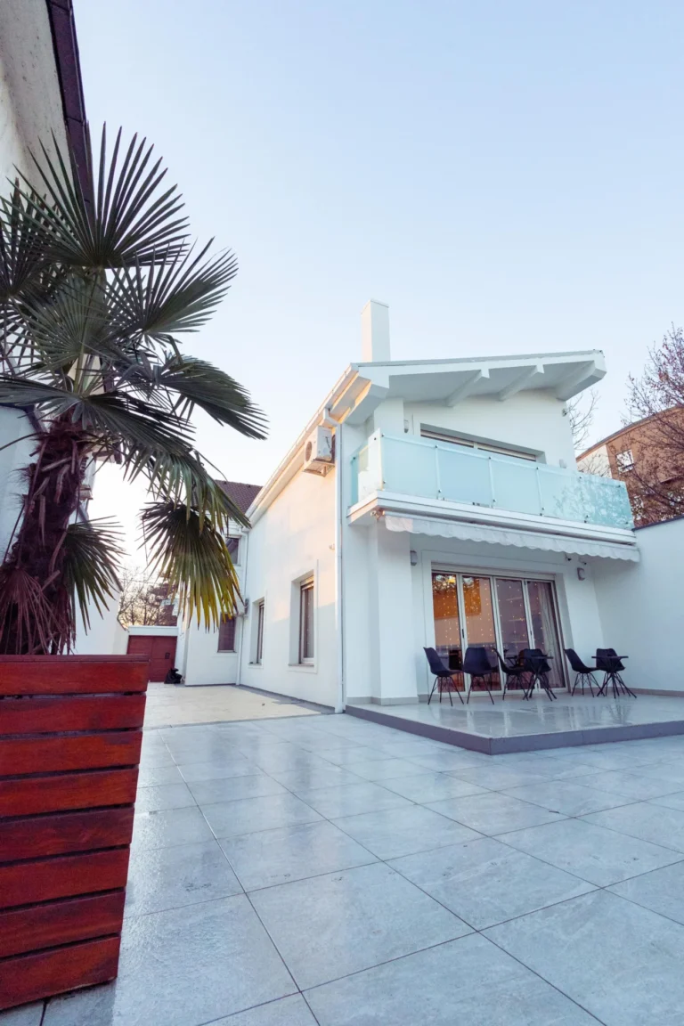 Modern white house with palm trees and an outdoor patio