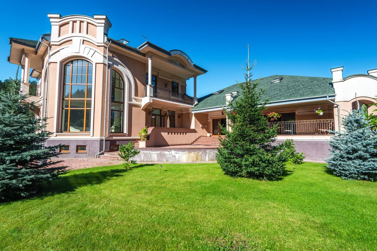 Modern villa with large windows and a green lawn