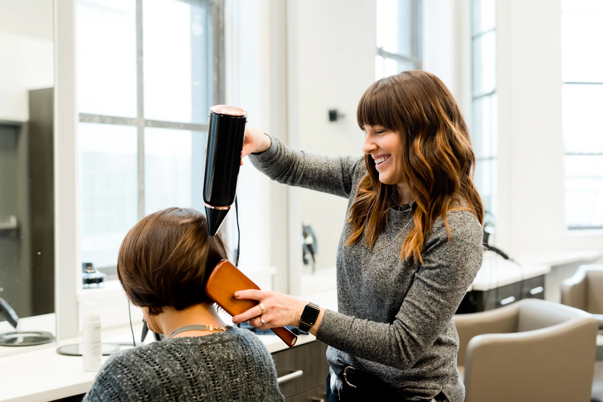 Stylist blow-drying a client’s hair